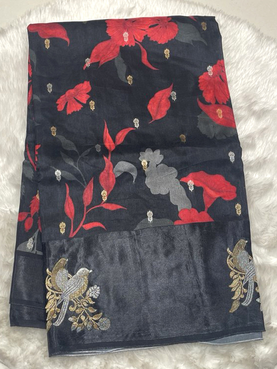 Midnight black Banarasi Bhagalpuri silk saree featuring large red floral prints and a wide satin silk border with silver and gold zari bird embroidery.