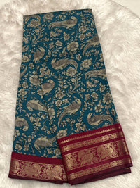 Teal blue Chhagal silk saree with floral Kalamkari prints and a rich maroon contrast gold zari border.
