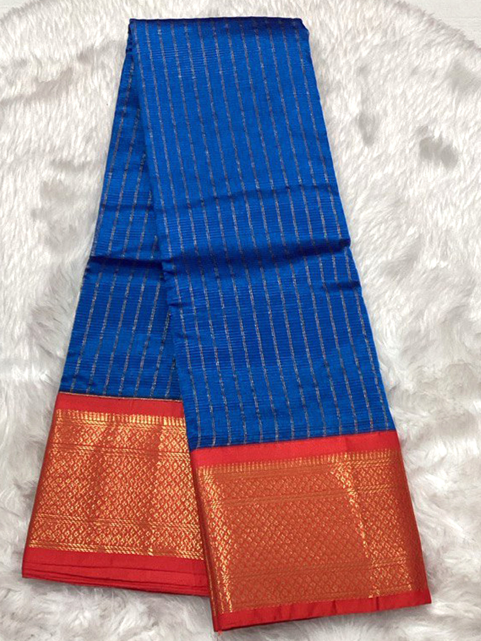 Golden cream Assam Pattu silk saree with traditional red and black hand-woven Muga-style motifs.