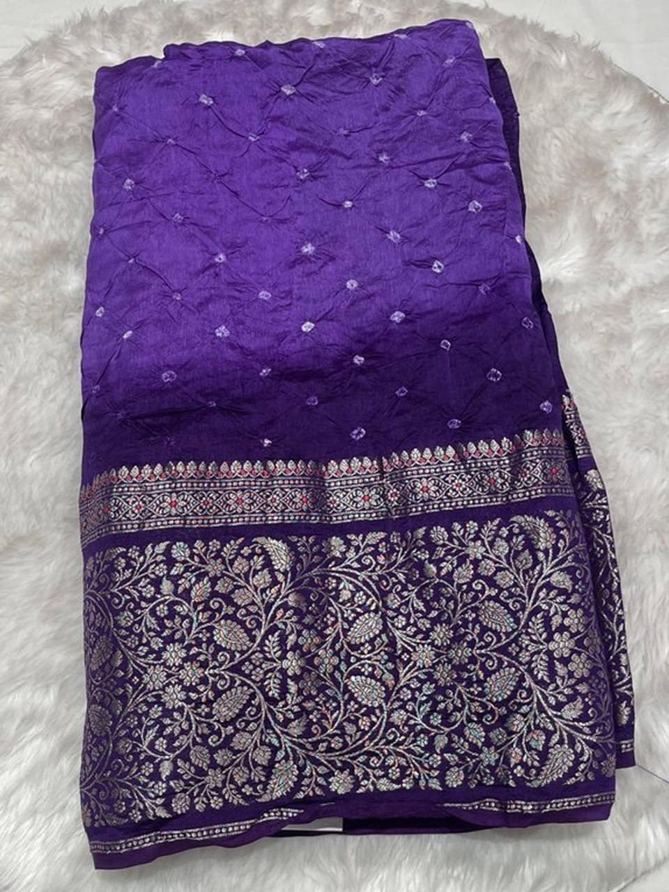 Deep purple shaded silk Bandhani saree featuring traditional tie-dye patterns and intricate zari work.