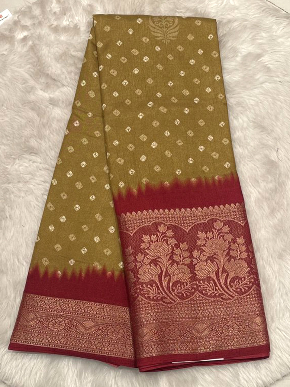 Mustard yellow Banarasi fancy saree with white Bandhani prints and a striking crimson red contrast woven border.