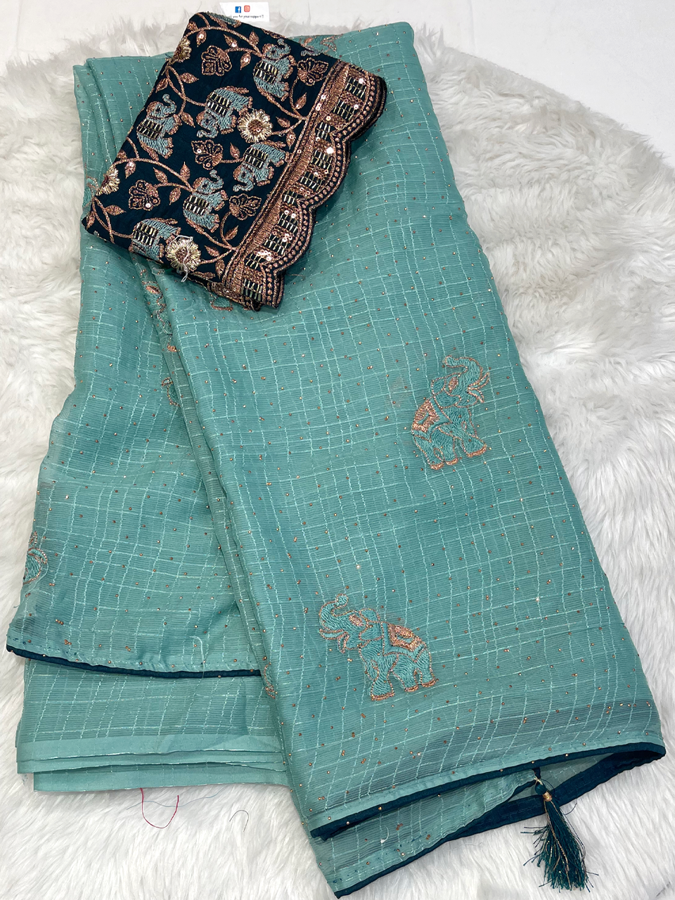 Sea green georgette saree with copper elephant motifs and black embroidered blouse