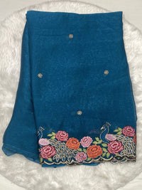 Peacock blue chiffon silk saree with intricate floral and peacock thread work embroidery on the border.