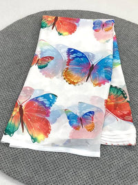 Full drape of white butterfly print saree featuring a kaleidoscope of colors including pink, green, and cyan.