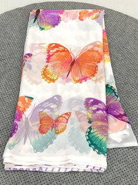 Folded fabric with colorful butterfly design on a gray surface