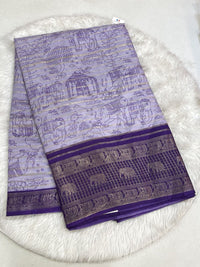 Lavender Dola silk saree with all-over horizontal zari weaving, traditional village scenery prints, and a deep purple contrast border with elephant and peacock motifs.