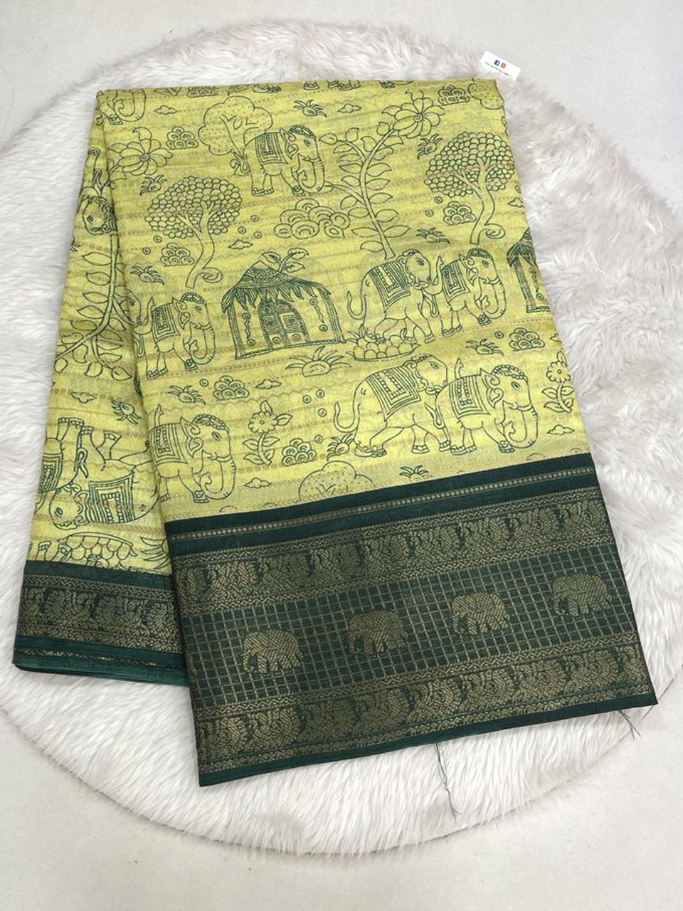 Lime green Dola silk saree with all-over zari weaving, featuring green elephant and tree prints with a dark bottle green contrast zari border.