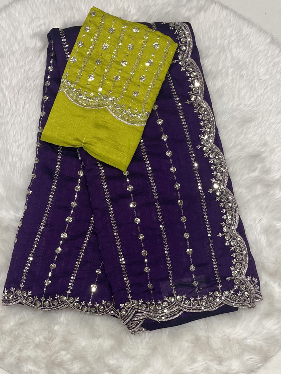 Deep purple party wear saree with gold zari work and scalloped edges, including a lime green heavy work blouse.