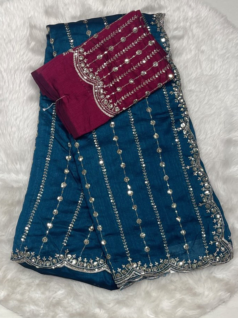 Peacock blue jute silk saree with silver/gold zari lines and magenta designer blouse with cutwork details.