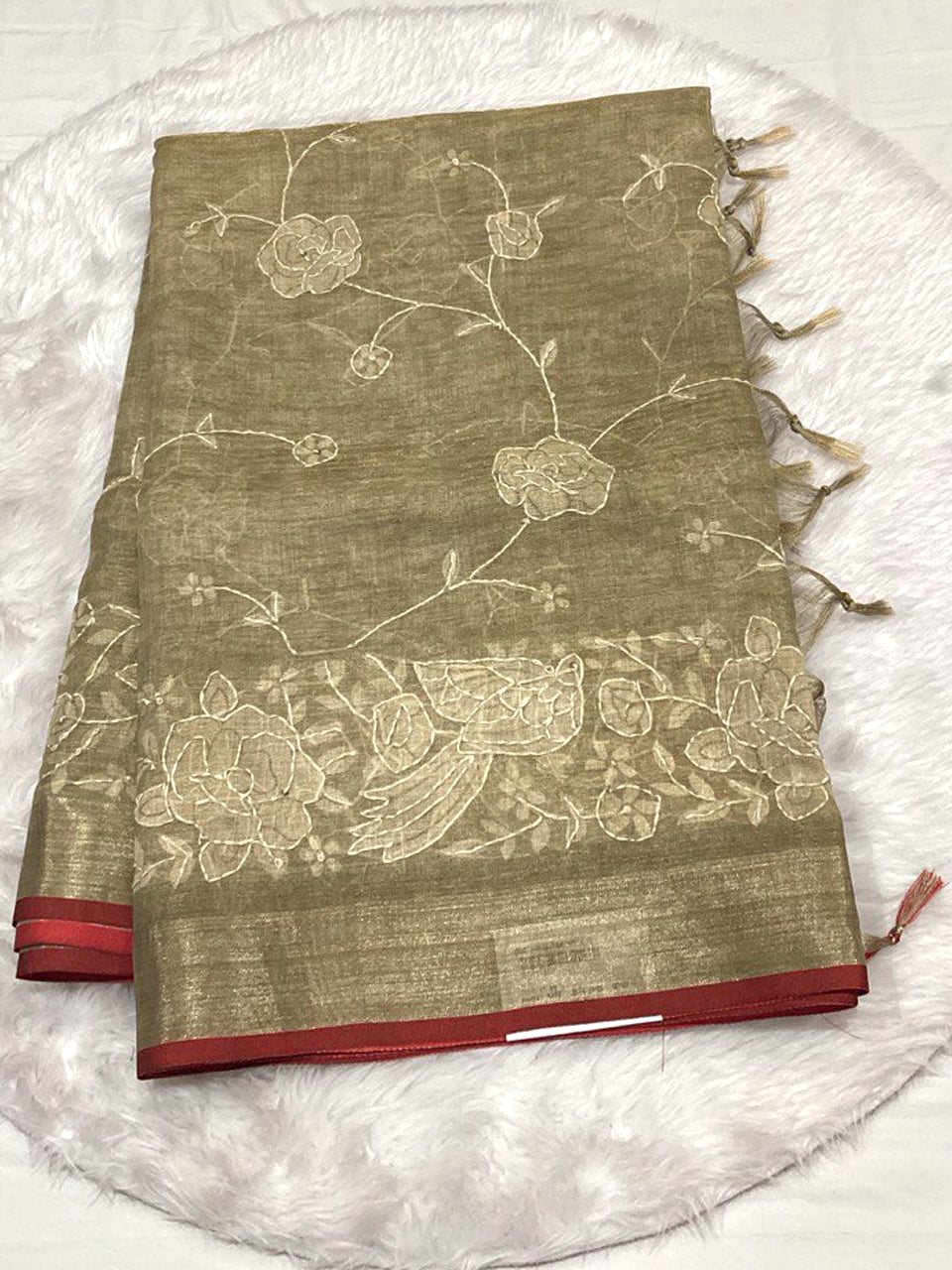 Olive gold Linen Tissue saree with white Lucknowi floral thread work, Zari border, and tassels.