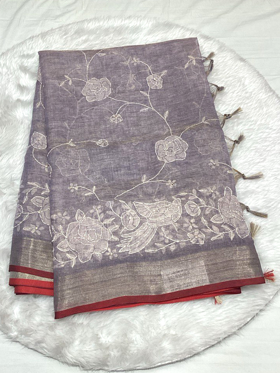 Dusty mauve Linen Tissue saree with white Lucknowi thread work and a shimmering metallic Zari border.