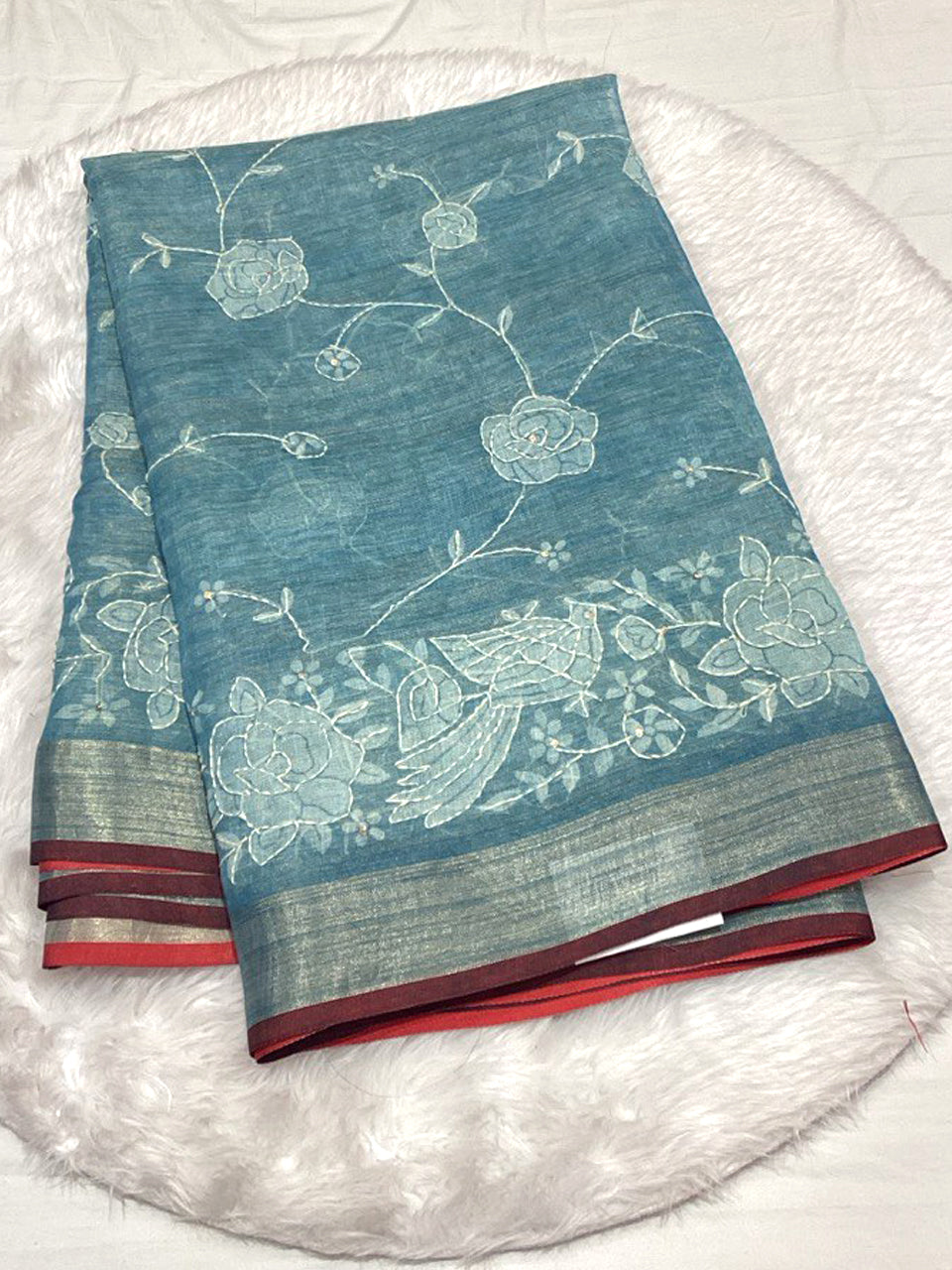 Ocean blue Linen Tissue saree featuring delicate floral Lucknowi embroidery and a refined Zari border.
