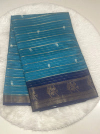 Teal blue Loreal silk saree with horizontal zari lines, rose bud motifs, and contrast navy blue gold zari border.
