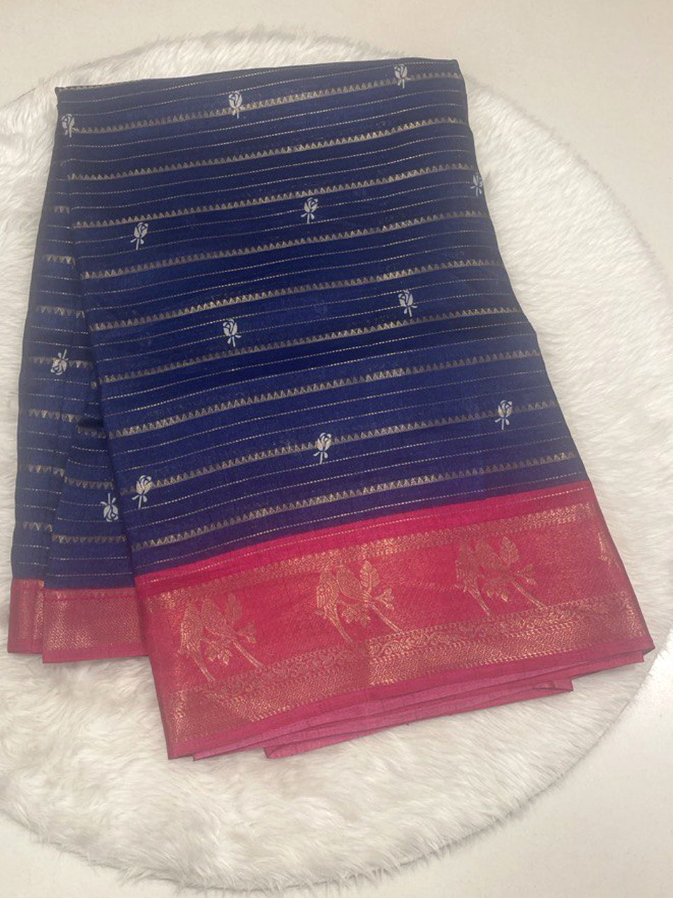 Navy blue Loreal silk saree with horizontal gold stripes and contrast Rani pink border featuring gold zari bird motifs.