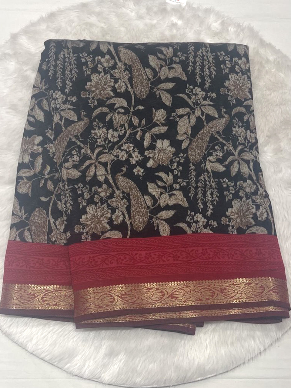 Black Maslin fancy saree featuring digital floral and peacock prints, finished with a contrast maroon red zari woven border.