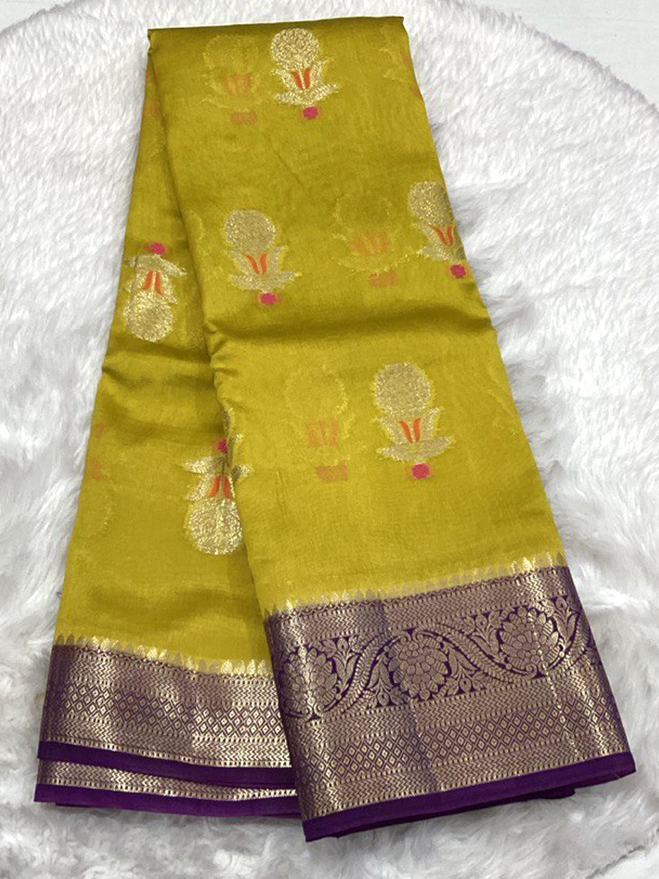 Mustard yellow Semi Green Mango silk saree adorned with gold Kalka buttis and a striking deep purple and gold Zari border.