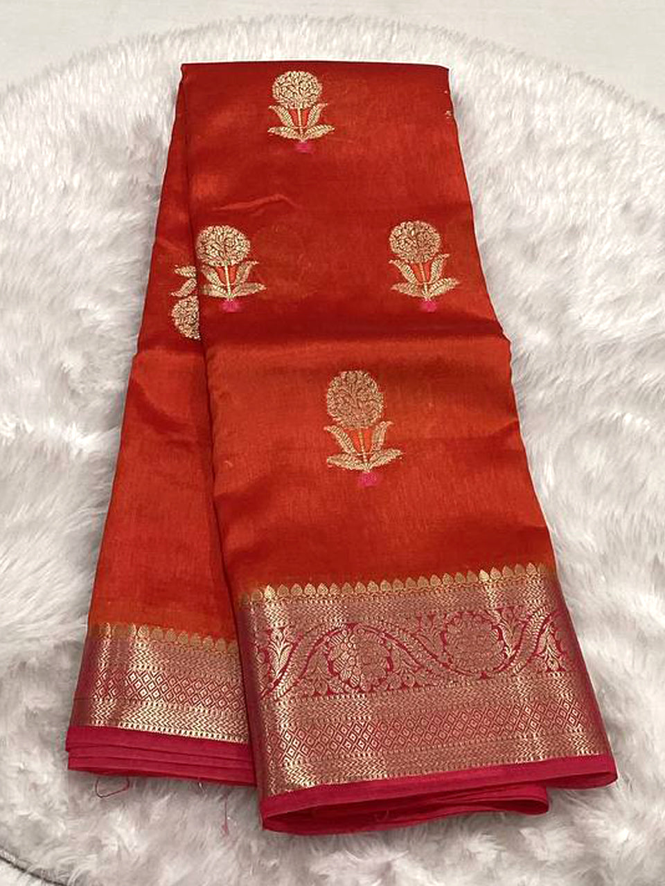 Burnt orange Semi Green Mango silk saree featuring woven gold Zari mango buttis and a broad fuchsia pink and gold floral Zari border.