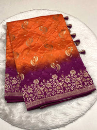 Orange and purple dual-tone Bandhani silk saree with gold zari floral border and tassels.