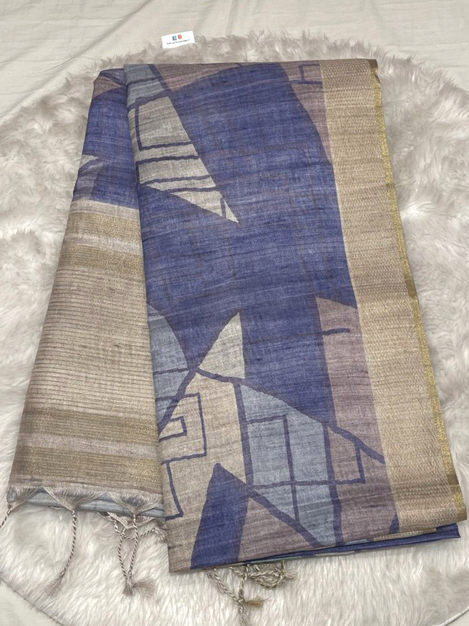 Slate blue Bhagalpuri Tussar silk saree with geometric abstract prints, gold zari border, and decorative pallu tassels.