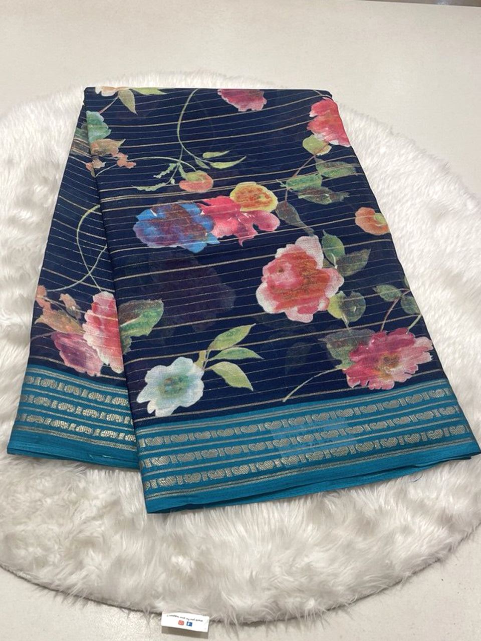 Navy Blue Micro Chiffon saree with floral print, zari lines, and teal contrast border.