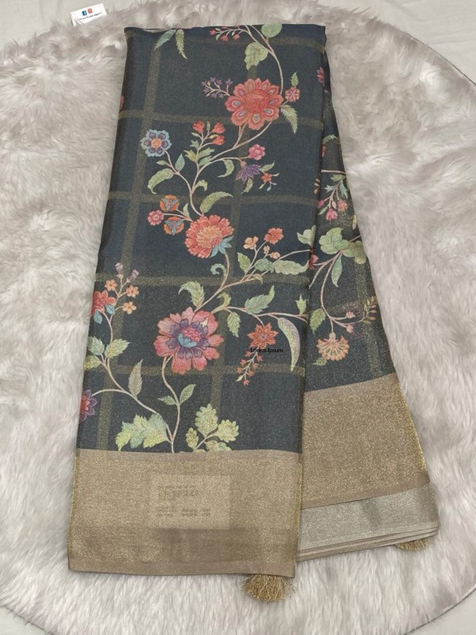 Charcoal grey Muslin Tissue saree featuring a grid-check pattern, colorful floral digital prints, and a wide gold tissue border.