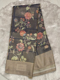 Rich chocolate brown Muslin Tissue saree with intricate floral digital printing and a metallic gold border.