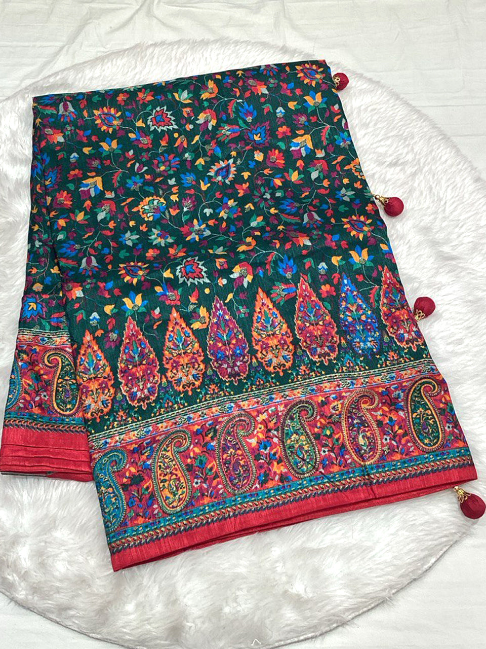 Emerald Green Dola Silk Saree with vibrant Patola floral patterns and a red Zari border with decorative tassels.