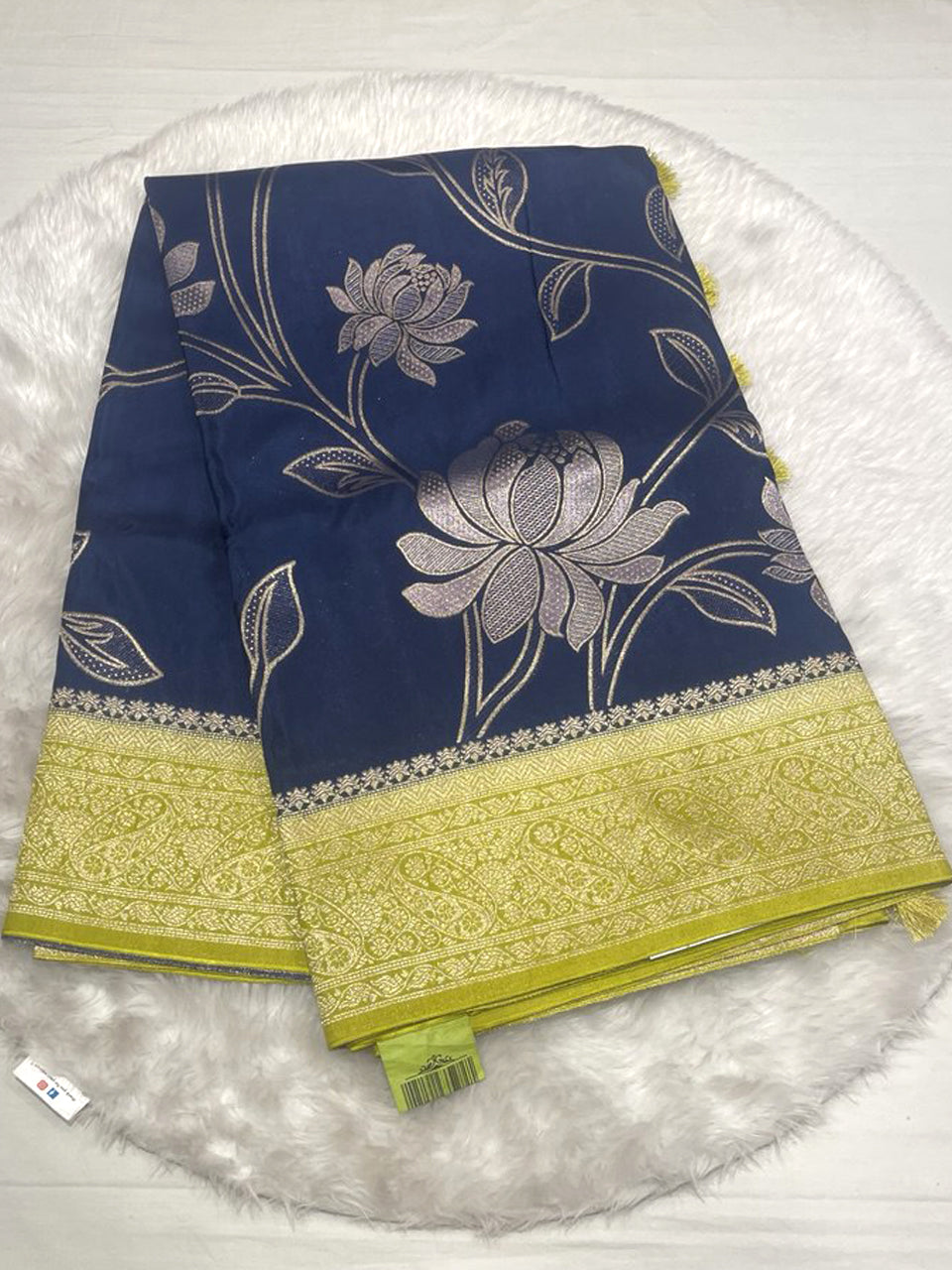 Navy blue Russian viscose silk saree with lime green Kanchi border and large silver floral motifs.