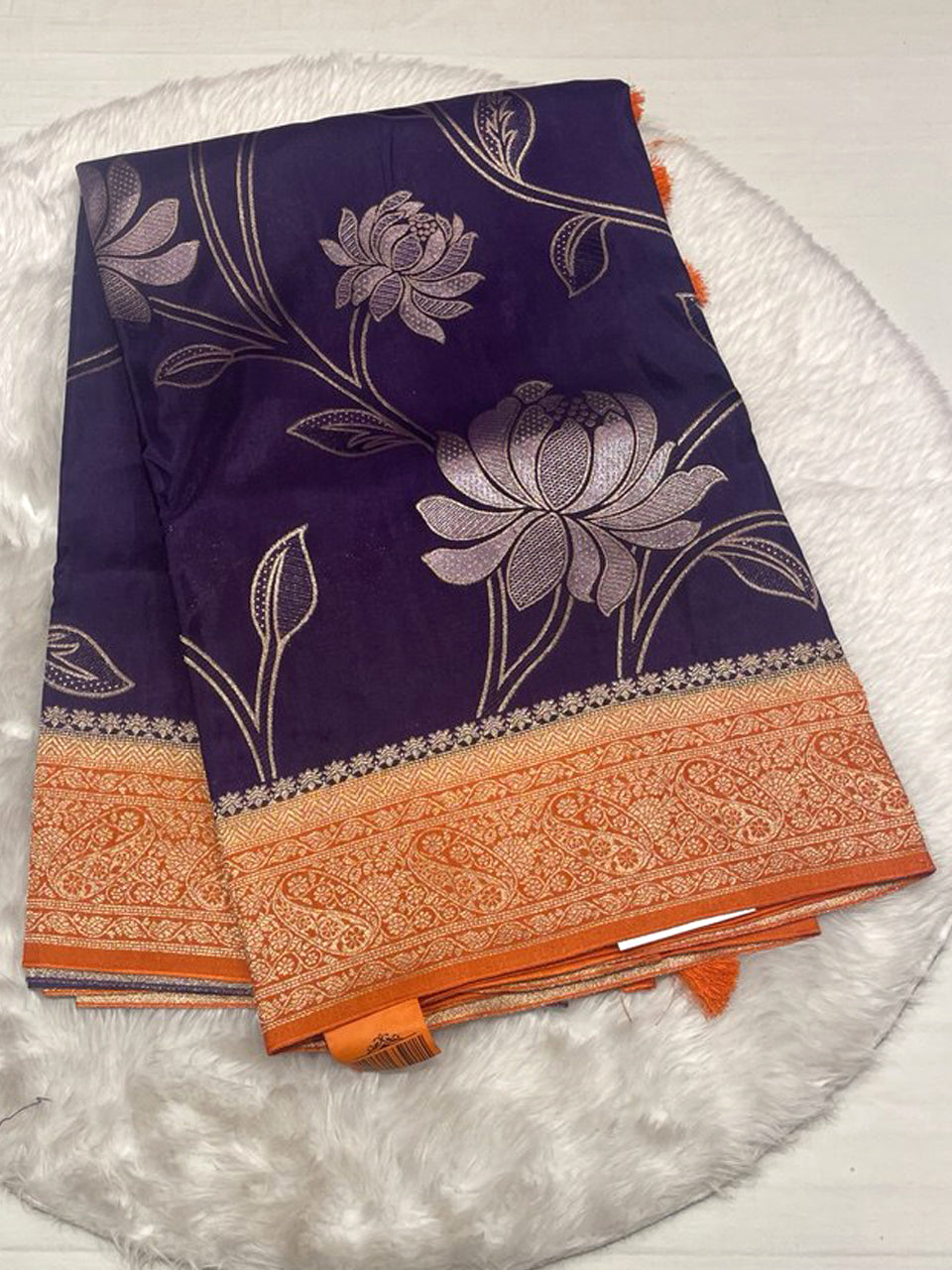 Deep plum purple Russian viscose silk saree with a contrasting bright orange zari border.