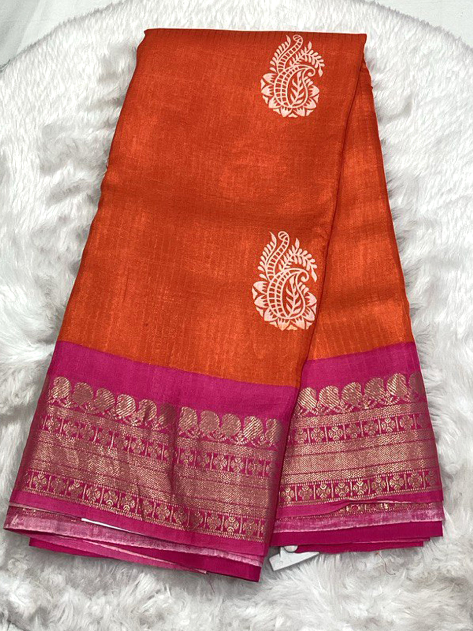 Burnt orange Mangalagiri silk-cotton saree with white paisley buttis and a magenta pink traditional zari-woven border.