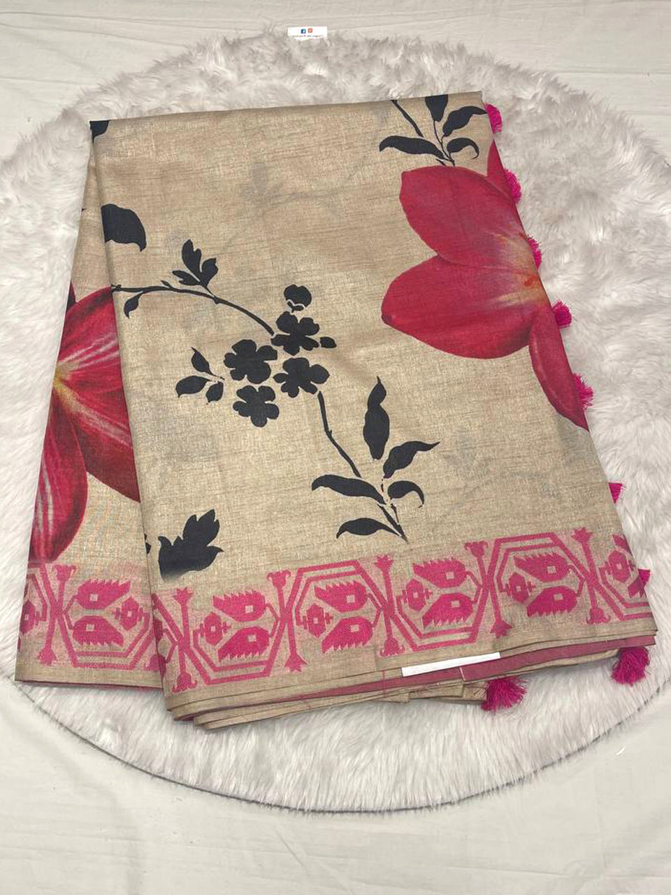Semi Tussar silk saree in beige with large pink digital floral prints and a pink woven leaf border with tassels.
