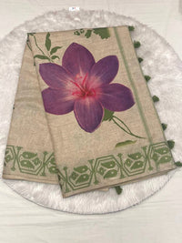 Beige semi Tussar saree featuring a bold purple flower print and a contrasting leaf green woven border.
