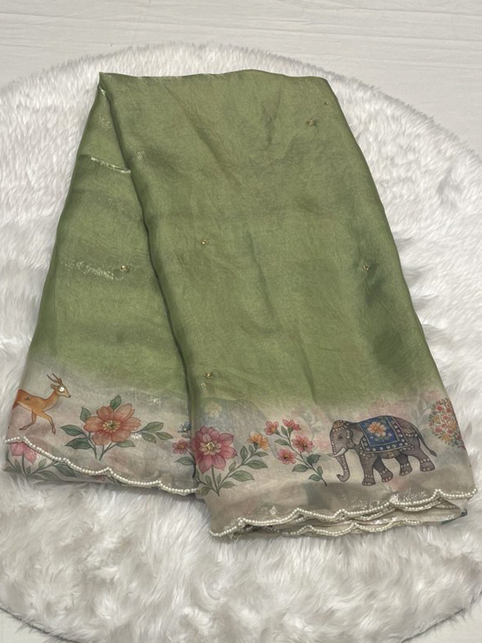 Olive green silky chiffon saree with kalamkari elephant and floral printed border, finished with delicate white mothi (pearl) scallop work.