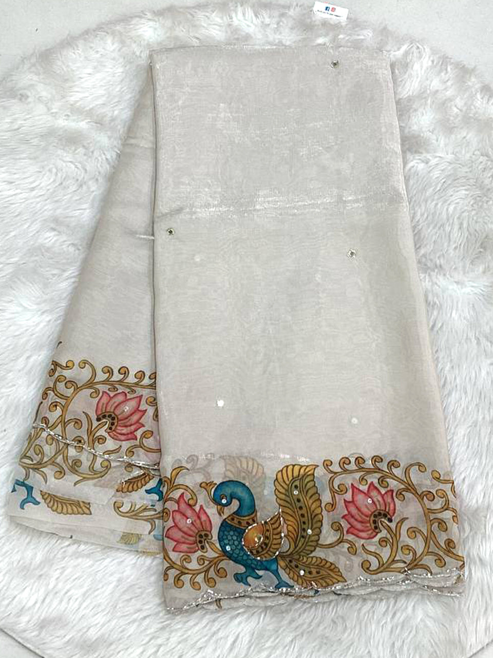 Mist grey space silk saree with an intricate Kalamkari-style peacock printed cutwork border and elegant bead buta embellishments.