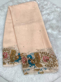 Soft peach space silk saree showcasing a vibrant peacock and lotus printed cutwork border with modern scalloped edges.