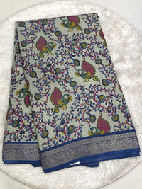 Rich emerald green Icon Silk saree with floral and bird motif embroidery and a signature silver scalloped lace border.