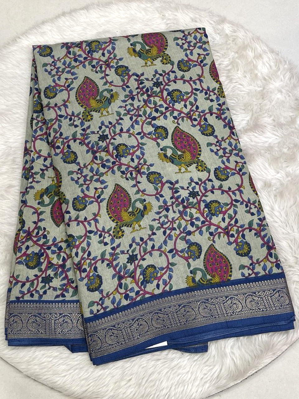 Rich emerald green Icon Silk saree with floral and bird motif embroidery and a signature silver scalloped lace border.