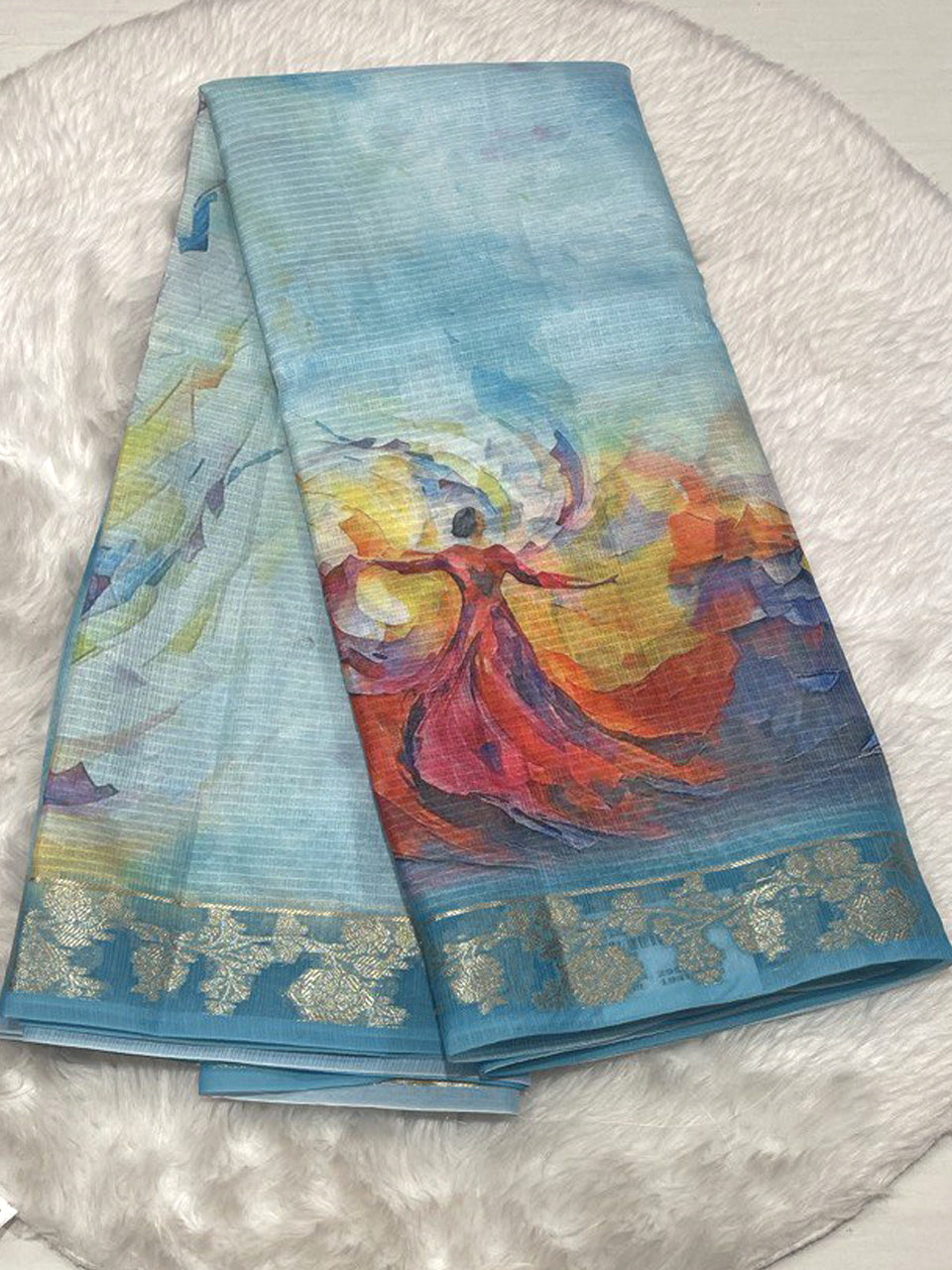 Cream-colored Zari Kota saree featuring a vibrant digital print of a dancing woman in a red dress and a gold floral Zari border.